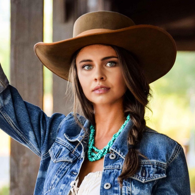 cowboy puts his hat on a girl